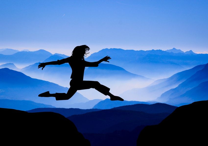 femme qui saute entre 2 montagnes pour se dépasser